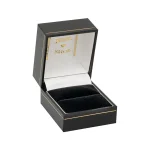 A black leatherette opened ring box with a thin gilt line around the top and the bottom part of the box were it opens and also a thin gilt border line around the very top of the box the inside where the ring goes is black velvet and the inside top lid is a white silk with jewel shop written in gold leaf