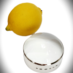 Spotlight effect on sterling silver surround, paired with glass dome—feature hallmark not visible, showcasing minimalist styling. Pictured next to a lemon for comparison.