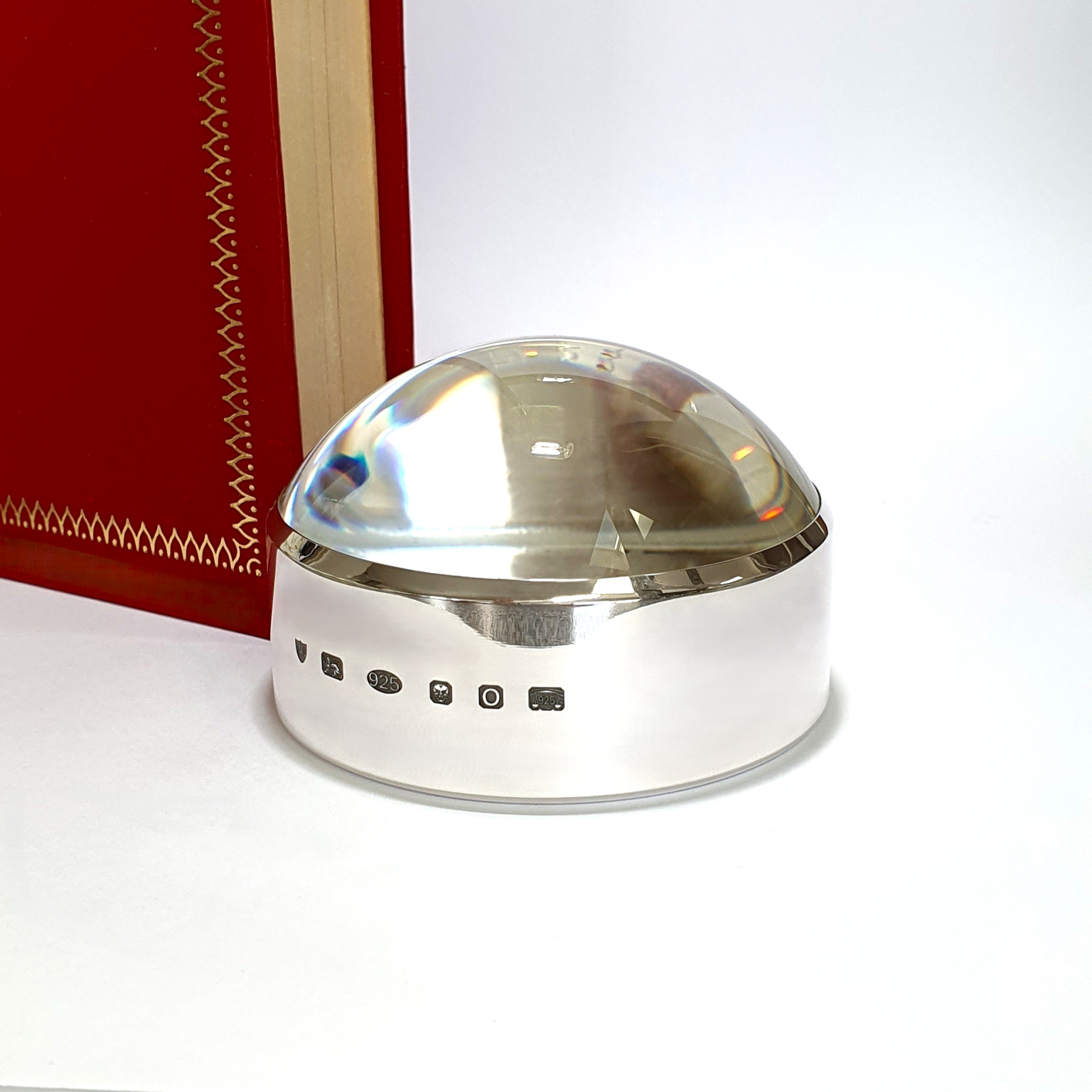 Close-up of sterling silver surround with feature British hallmark, highlighting artisan detail and official authenticity. Pictured next to a red book.