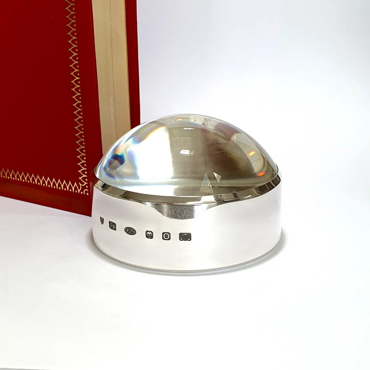 Close-up of sterling silver surround with feature British hallmark, highlighting artisan detail and official authenticity. Pictured next to a red book.