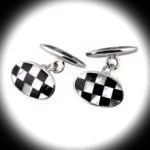 Oval black and white chequered sterling silver chain‑link cufflinks shown on a black background with a focused white spotlight