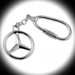 Sterling silver Mercedes keyring fob displayed on a white background with a soft spotlight effect, highlighting the contours of the emblem against subtly darkened edges. Crafted in hallmarked silver for guaranteed purity and quality.