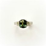Top view of the platinum ring showing the green sapphire and half‑moon diamonds.