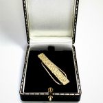 Melted gold bar effect for your cash, pictured at right angle sitting in a black jewellery box.