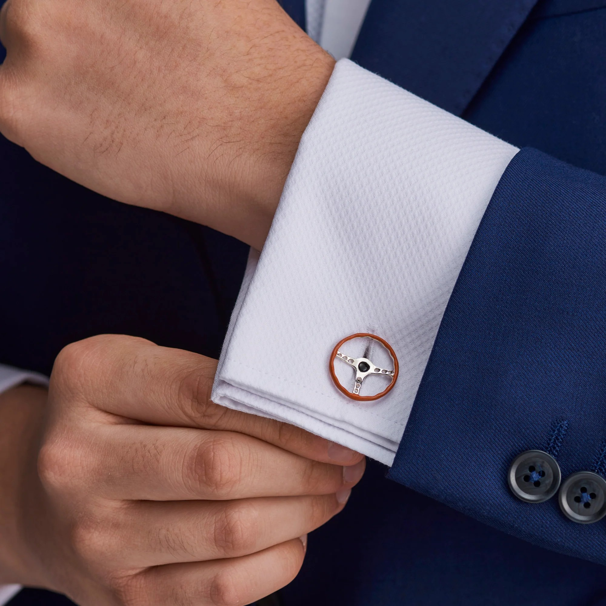 Sterling silver retro steering wheel cufflinks with vitreous brown enamel to imitate the leather cover pictured on a shirt cuff.