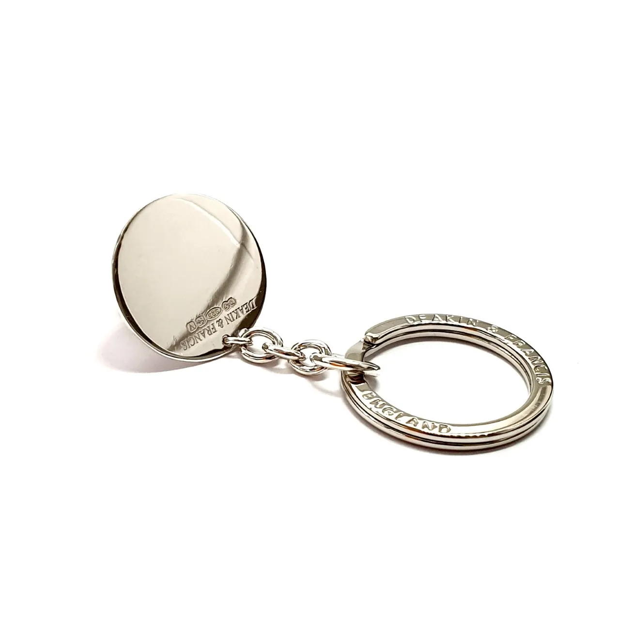 Genuine 925 silver key ring with the face of a Dachshund dog with blue sapphire eyes. Showing the back disc.