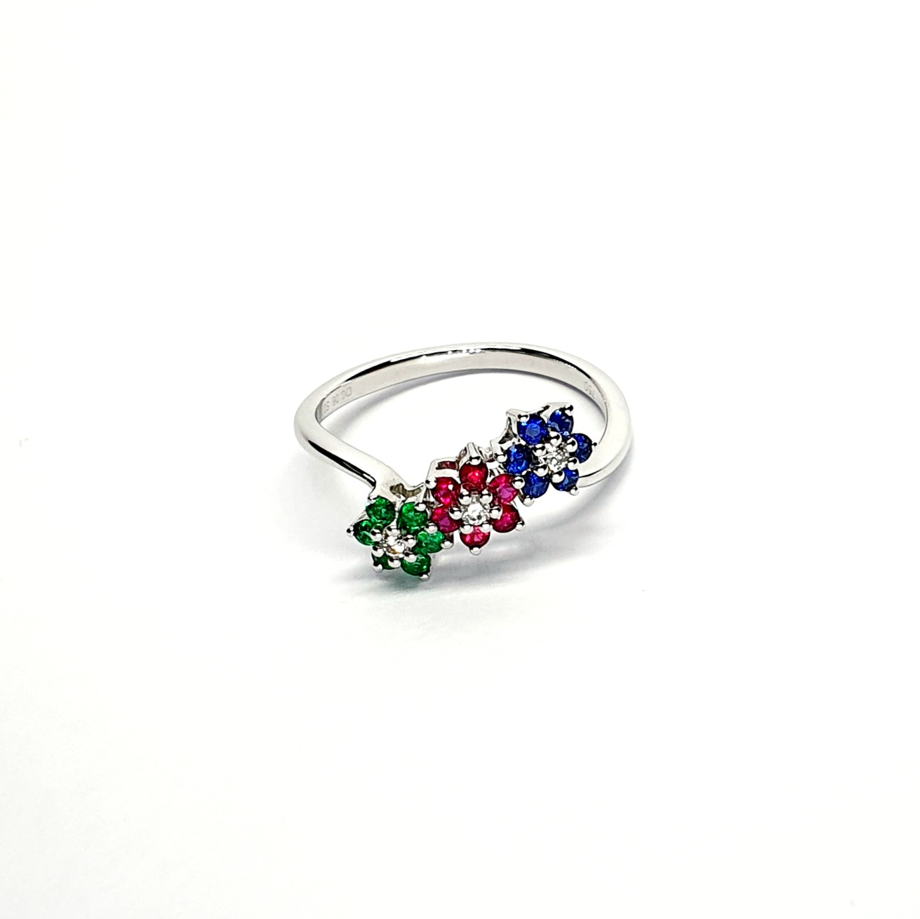 "18ct White Gold Sapphire, Ruby, Emerald & Diamond Three-Cluster Ring: Mesmerizing beauty with vibrant gemstones, exquisite craftsmanship, elegant crossover wave shank, and unmatched quality."