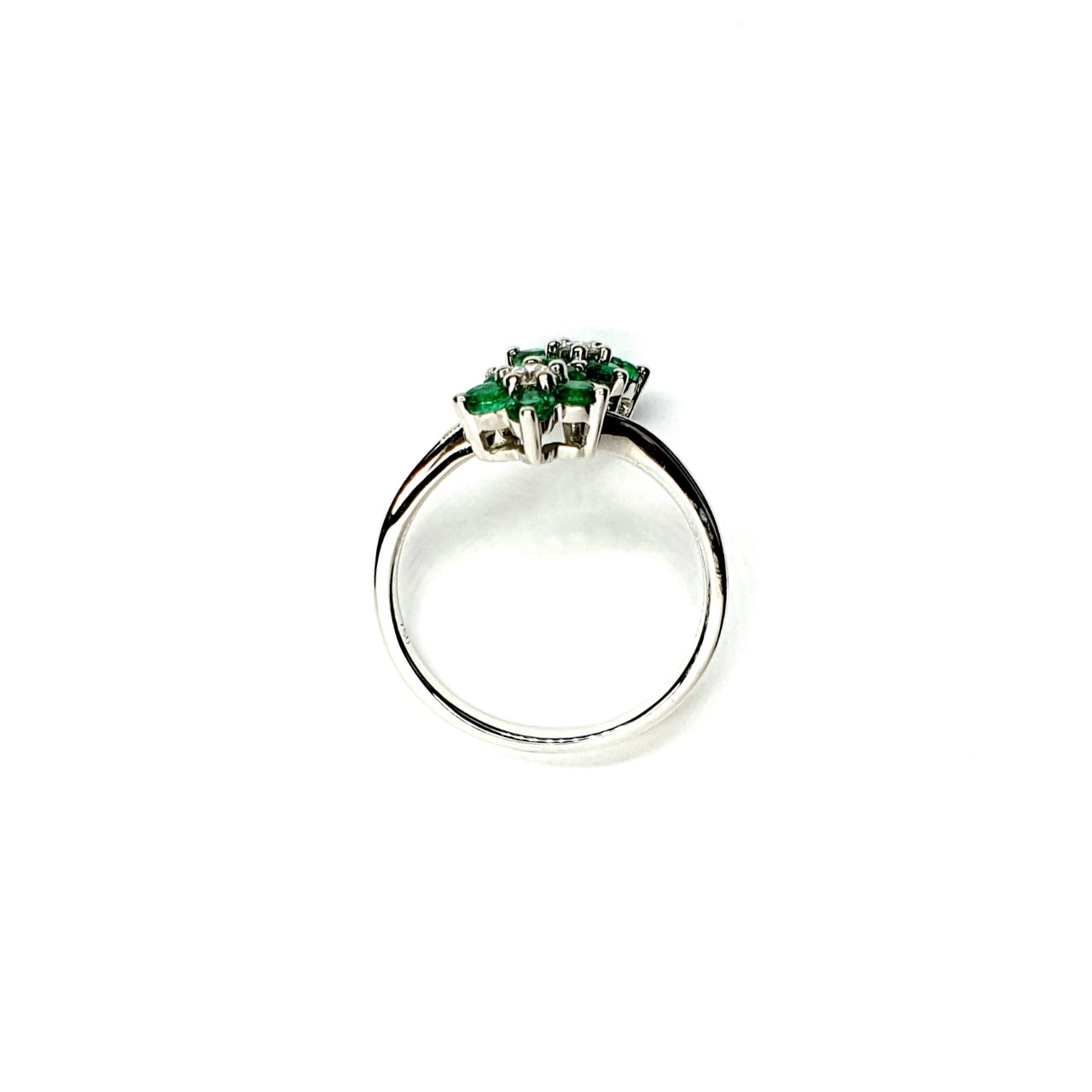 Double Cluster Emerald Ring. Crafted in 18ct white gold featuring two clusters of five round bright green emeralds with a single diamond to the centre of each cluster, with a wave cross over shank