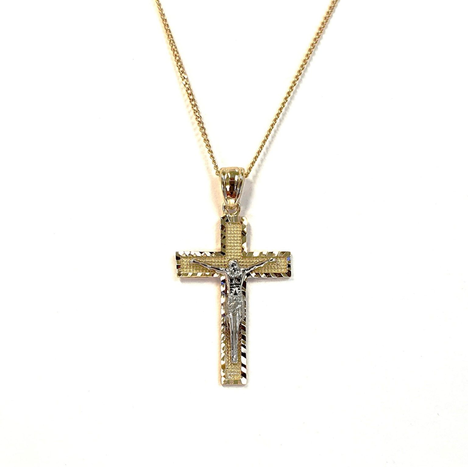 A yellow gold cross with an intricate white gold Jesus & a chris cross matt background with a contrasting sparkling diamond cut patterned edging.