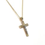 A yellow gold cross with an intricate white gold Jesus & a chris cross matt background with a contrasting sparkling diamond cut patterned edging.