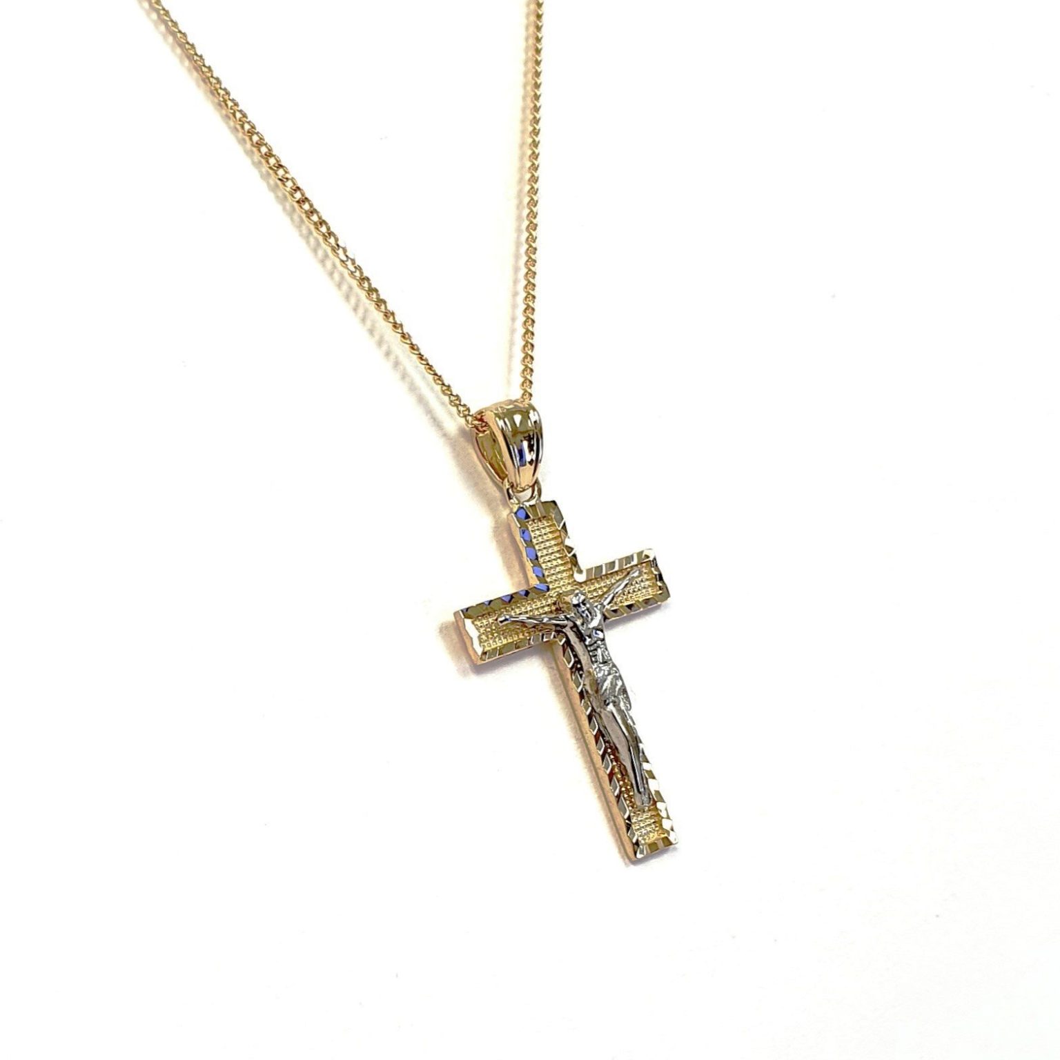 A yellow gold cross with an intricate white gold Jesus & a chris cross matt background with a contrasting sparkling diamond cut patterned edging.