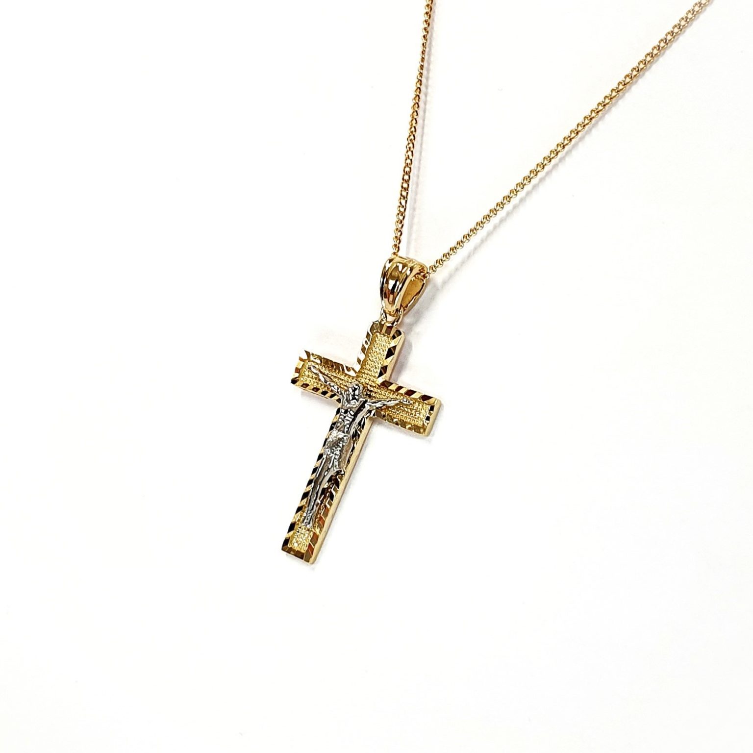 A yellow gold cross with an intricate white gold Jesus & a chris cross matt background with a contrasting sparkling diamond cut patterned edging.