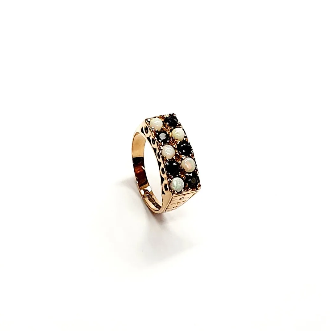 Vintage 1979 opal & dark blue sapphire 9ct gold landscape rectangular top ring measuring 18mm x 7.8mm set with five round cabochon cut opals & five round dark blue sapphires in a chequer formation with three hand engraved flowers to both—side shoulders.