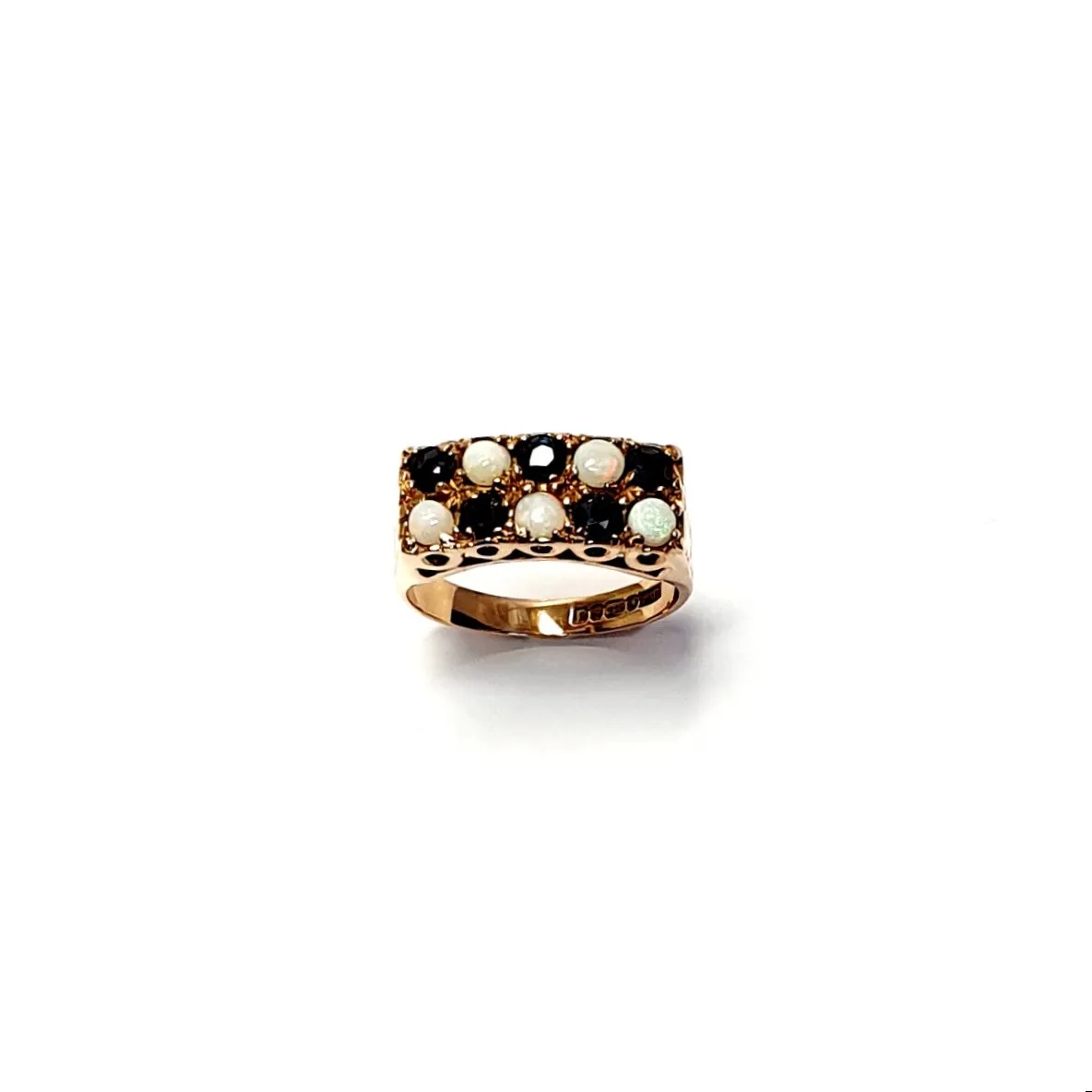 Vintage 1979 opal & dark blue sapphire 9ct gold landscape rectangular top ring measuring 18mm x 7.8mm set with five round cabochon cut opals & five round dark blue sapphires in a chequer formation with three hand engraved flowers to both—side shoulders.