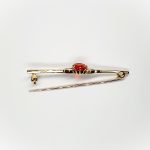 A handmade 9ct yellow gold bar brooch 52mm long set with a gorgeous top quality oval fire opal measuring 8.6mm x 7mm portrait set to the middle of the bar with three 9ct gold diamond shapes to each side of the stone with a straight pin to the back with a swivel safety catch.