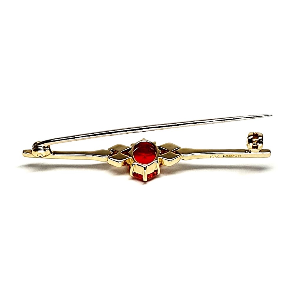 A handmade 9ct yellow gold bar brooch 52mm long set with a gorgeous top quality oval fire opal measuring 8.6mm x 7mm portrait set to the middle of the bar with three 9ct gold diamond shapes to each side of the stone with a straight pin to the back with a swivel safety catch.