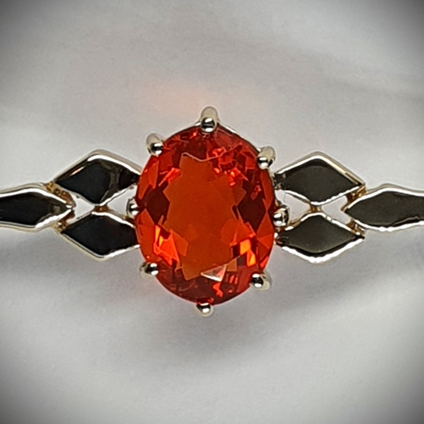 A handmade 9ct yellow gold bar brooch 52mm long set with a gorgeous top quality oval fire opal measuring 8.6mm x 7mm portrait set to the middle of the bar with three 9ct gold diamond shapes to each side of the stone with a straight pin to the back with a swivel safety catch.