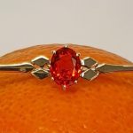 A handmade 9ct yellow gold bar brooch 52mm long set with a gorgeous top quality oval fire opal measuring 8.6mm x 7mm portrait set to the middle of the bar with three 9ct gold diamond shapes to each side of the stone with a straight pin to the back with a swivel safety catch.