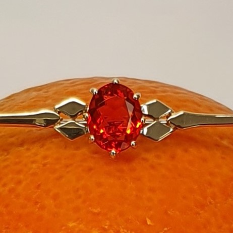 A handmade 9ct yellow gold bar brooch 52mm long set with a gorgeous top quality oval fire opal measuring 8.6mm x 7mm portrait set to the middle of the bar with three 9ct gold diamond shapes to each side of the stone with a straight pin to the back with a swivel safety catch.