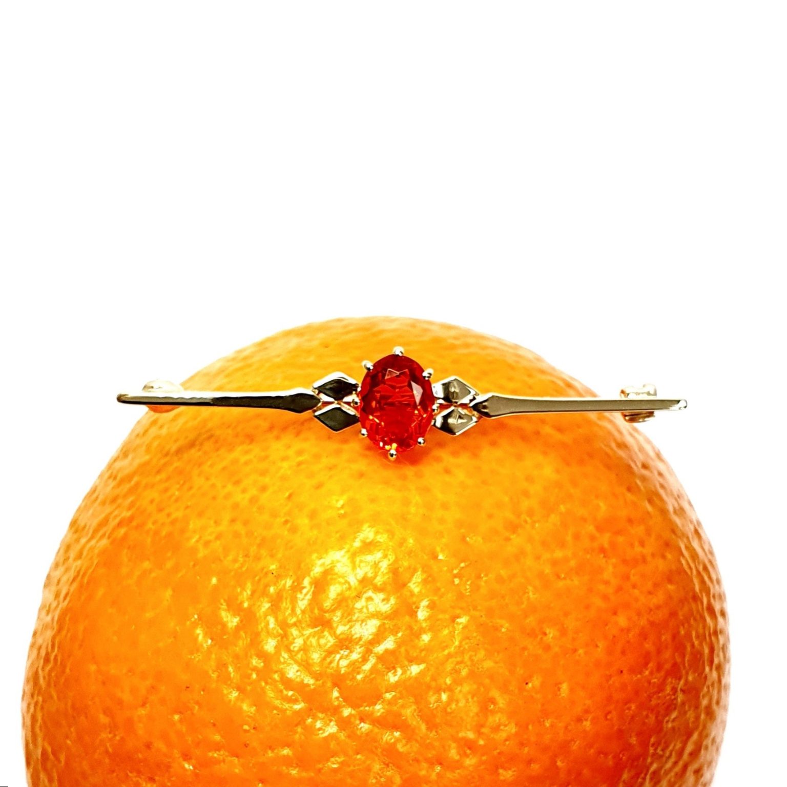 A handmade 9ct yellow gold bar brooch 52mm long set with a gorgeous top quality oval fire opal measuring 8.6mm x 7mm portrait set to the middle of the bar with three 9ct gold diamond shapes to each side of the stone with a straight pin to the back with a swivel safety catch.