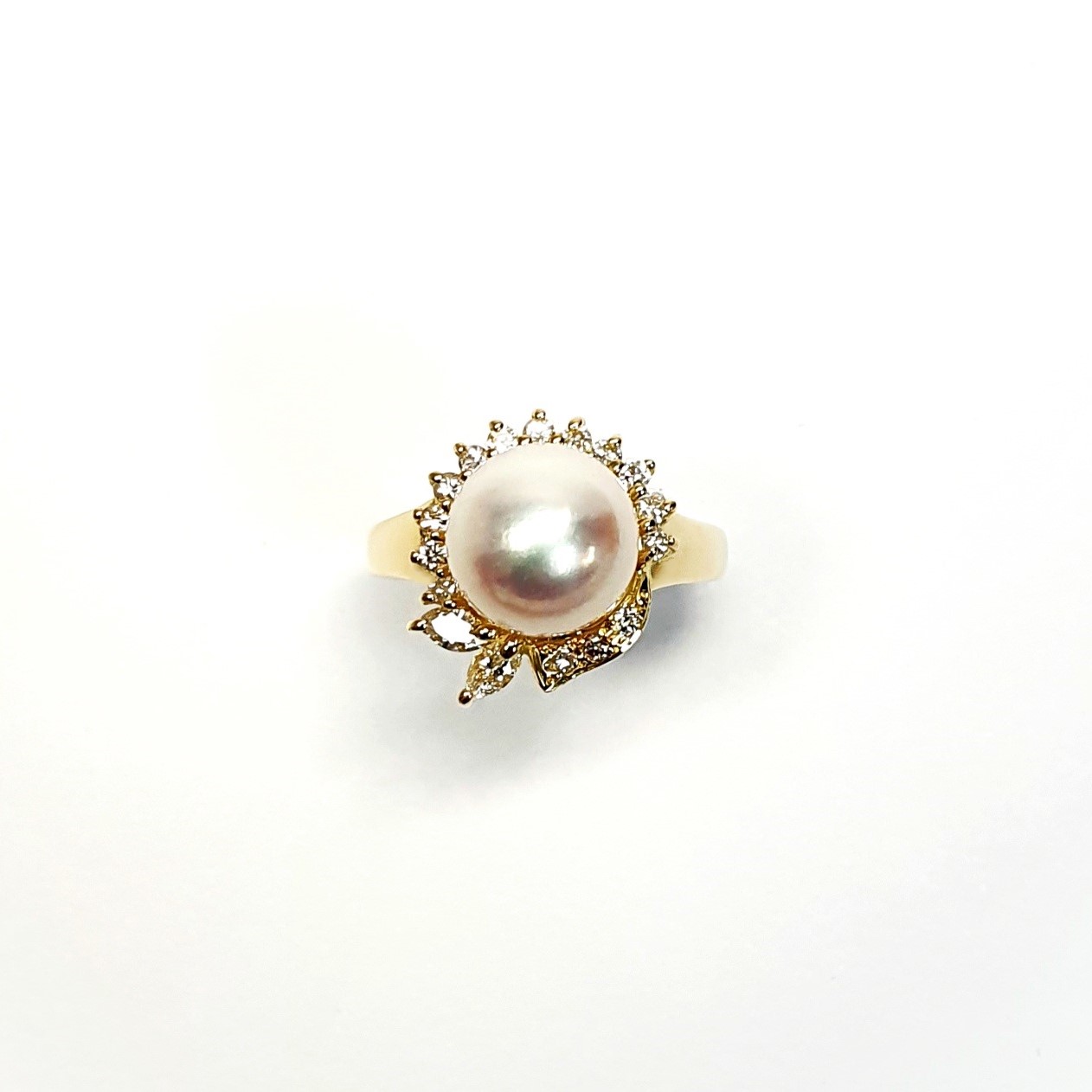 View of the top of the ring looking down on the top with the two marquise diamonds facing to the bottom of the picture they are crafted in 18ct yellow gold set with a single round 9mm cultured pearl surrounded by fifteen sparkling white round diamonds and two marquise-shaped diamonds with a total diamond weight of 0.31 carats.