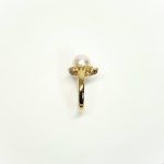 View of the side shoulder of the ring Marquise stones facing right They are crafted in 18ct yellow gold set with a single round 9mm cultured pearl surrounded by fifteen sparkling white round diamonds and two marquise-shaped diamonds with a total diamond weight of 0.31 carats.