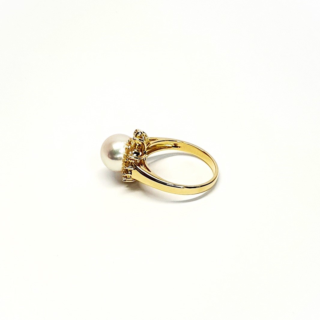 View from the back of the ring laying down top facing left They are crafted in 18ct yellow gold set with a single round 9mm cultured pearl surrounded by fifteen sparkling white round diamonds and two marquise-shaped diamonds with a total diamond weight of 0.31 carats.