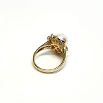 View from the back of the ring laying down top facing right They are crafted in 18ct yellow gold set with a single round 9mm cultured pearl surrounded by fifteen sparkling white round diamonds and two marquise-shaped diamonds with a total diamond weight of 0.31 carats.