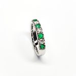 18ct White Gold Emerald & Diamond Eternity Ring RA00685 Four 2.8mm round emeralds and three 2.8mm round diamonds ring standing up to the front angled facing to the right. Close up with a white background
