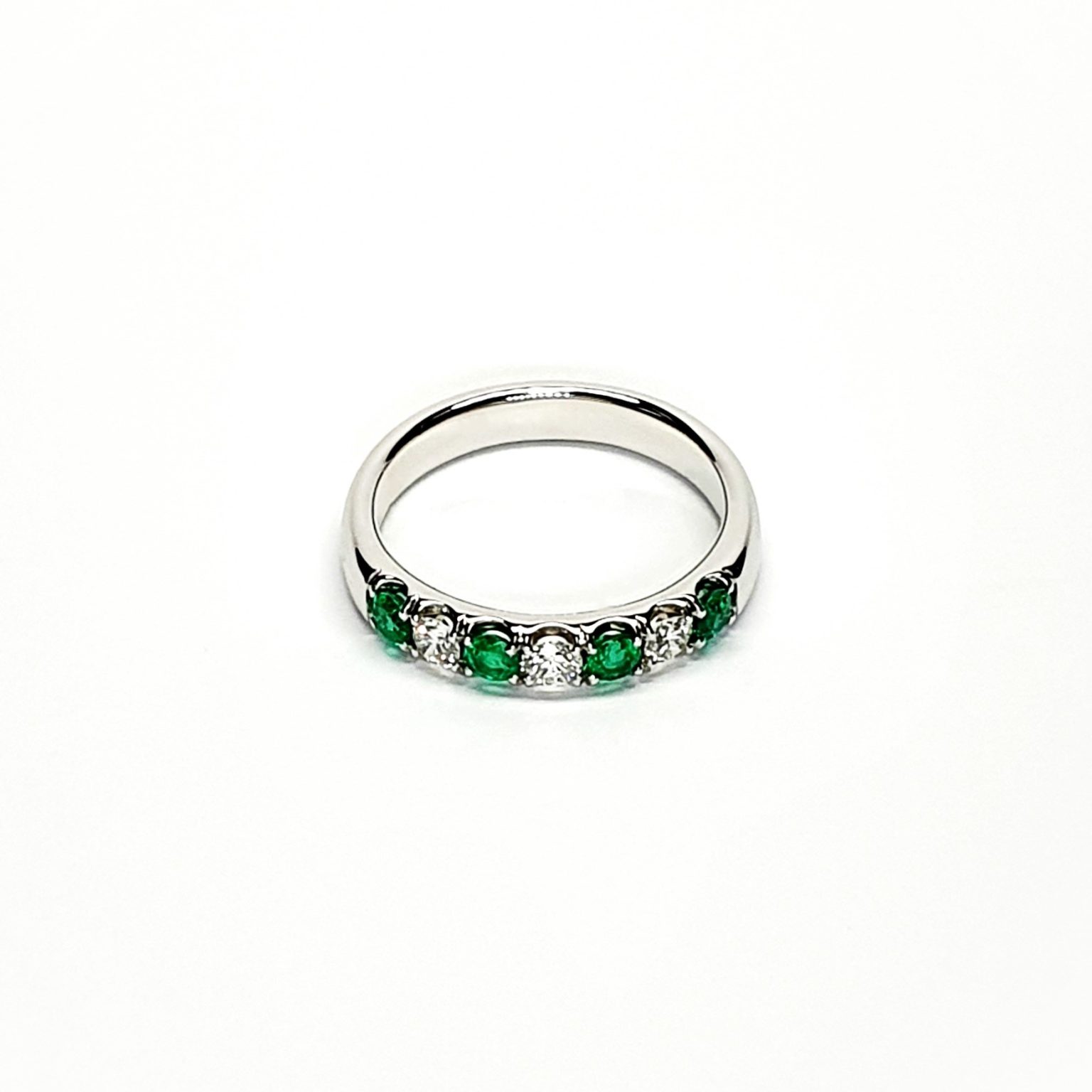 18ct White Gold Emerald & Diamond Eternity Ring RA00685 Four 2.8mm round emeralds and three 2.8mm round diamonds ring laying down front view.