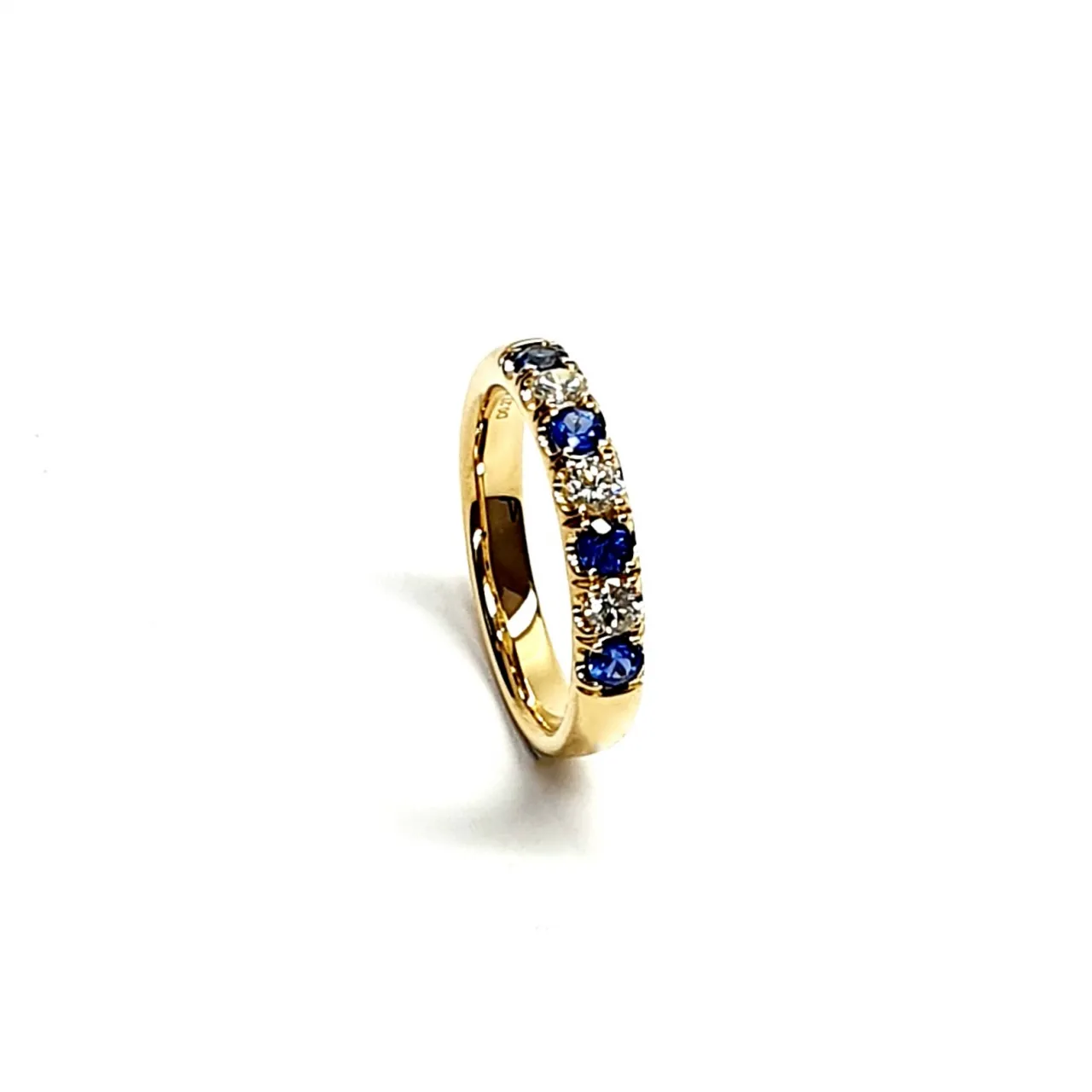 18ct Yellow Gold Blue Sapphire & Diamond Eternity Ring RA00686 Four 2.8mm round sapphires and three 2.8mm round diamonds ring standing up to the front angled facing to the right. Close up with a white background