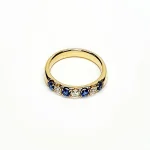 18ct Yellow Gold Sapphire & Diamond Eternity Ring RA00686 Four 2.8mm round sapphires and three 2.8mm round diamonds ring laying down front view.