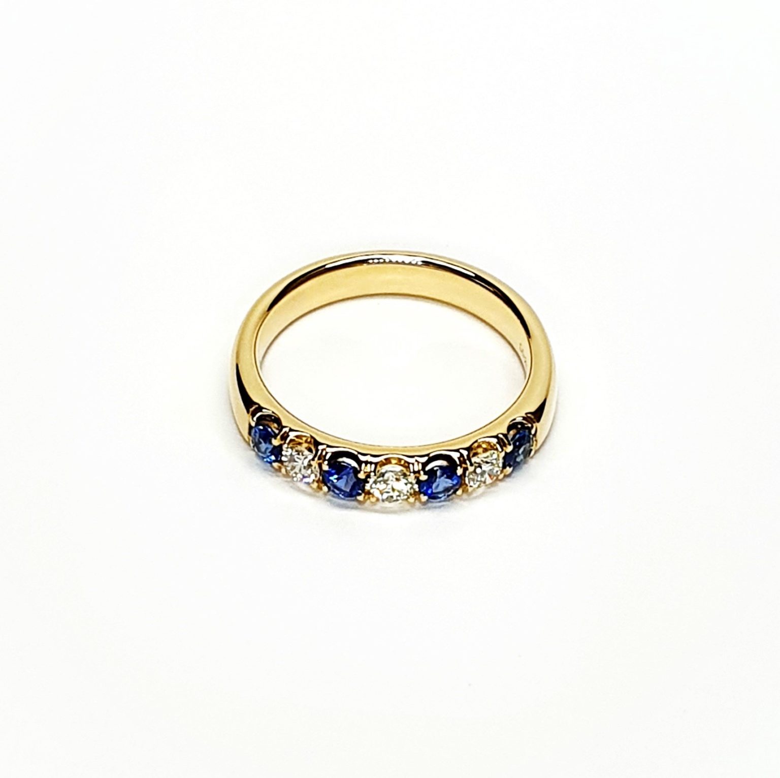 18ct Yellow Gold Sapphire & Diamond Eternity Ring RA00686 Four 2.8mm round sapphires and three 2.8mm round diamonds ring laying down front view.