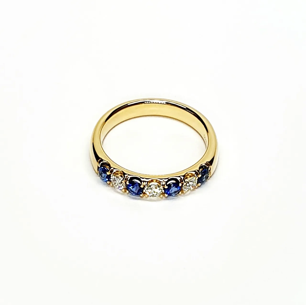 18ct Yellow Gold Sapphire & Diamond Eternity Ring RA00686 Four 2.8mm round sapphires and three 2.8mm round diamonds ring laying down front view.