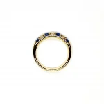 18ct Yellow Gold Sapphire & Diamond Eternity Ring RA00686 Four 2.8mm round sapphires and three 2.8mm round diamonds ring laying down side view.
