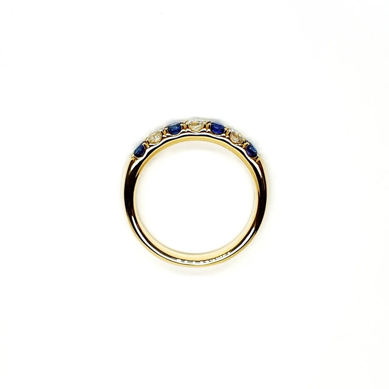 18ct Yellow Gold Sapphire & Diamond Eternity Ring RA00686 Four 2.8mm round sapphires and three 2.8mm round diamonds ring laying down side view.