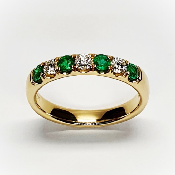 18ct yellow gold seven-stone eternity ring 3.5mm wide set with four 2.8mm round emeralds and three 2.8mm round diamonds in four claw settings