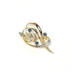 9ct yellow gold brooch with a sprig of seven leaves coming through a floral swirl of polished and barked yellow gold with three diamonds set into a small white rhodium section 