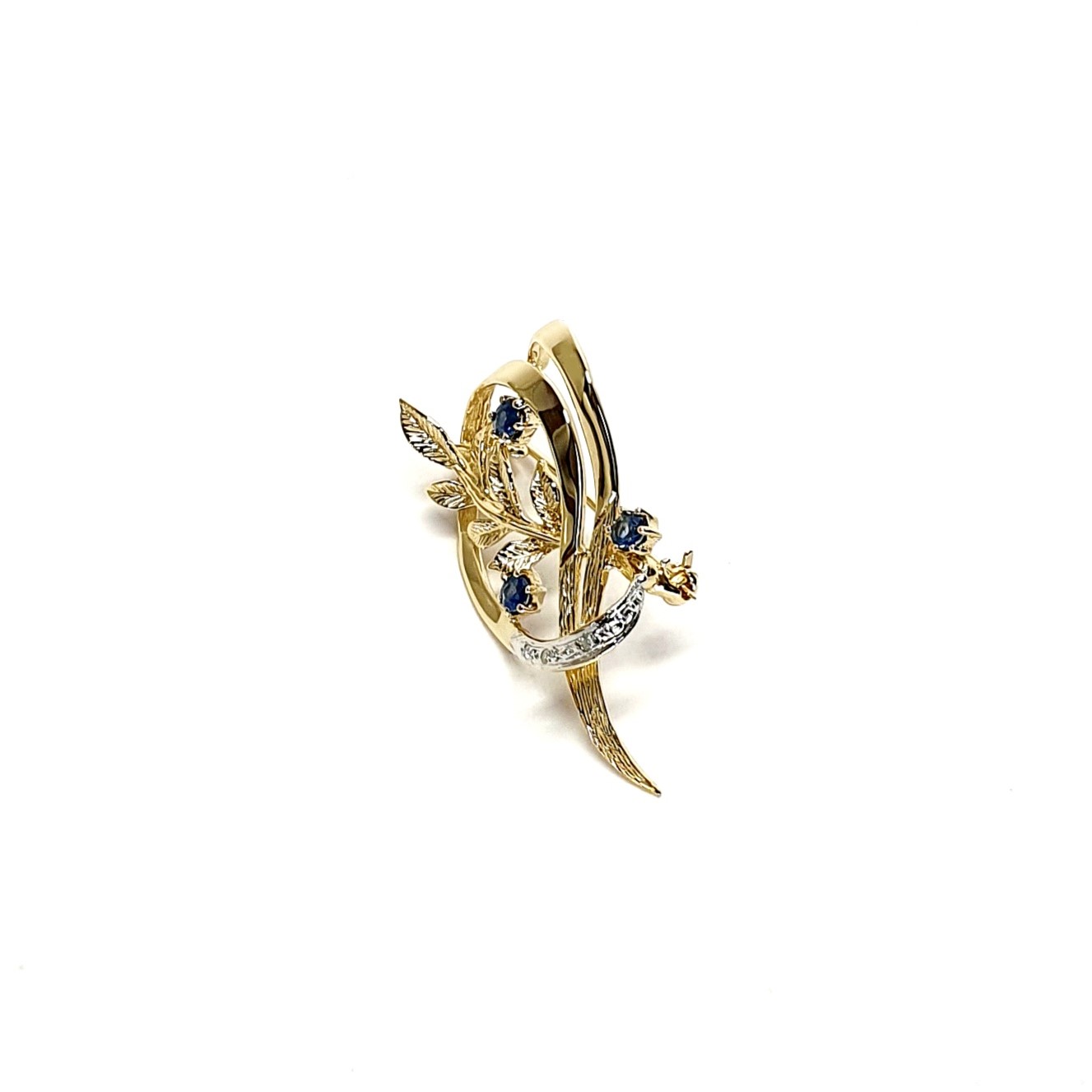 9ct yellow gold brooch with a sprig of seven leaves coming through a floral swirl of polished and barked yellow gold with three diamonds set into a small white rhodium section 