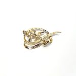9ct yellow gold brooch with a sprig of seven leaves coming through a floral swirl of polished and barked yellow gold with three diamonds set into a small white rhodium section 