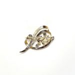 9ct yellow gold brooch with a sprig of seven leaves coming through a floral swirl of polished and barked yellow gold with three diamonds set into a small white rhodium section 
