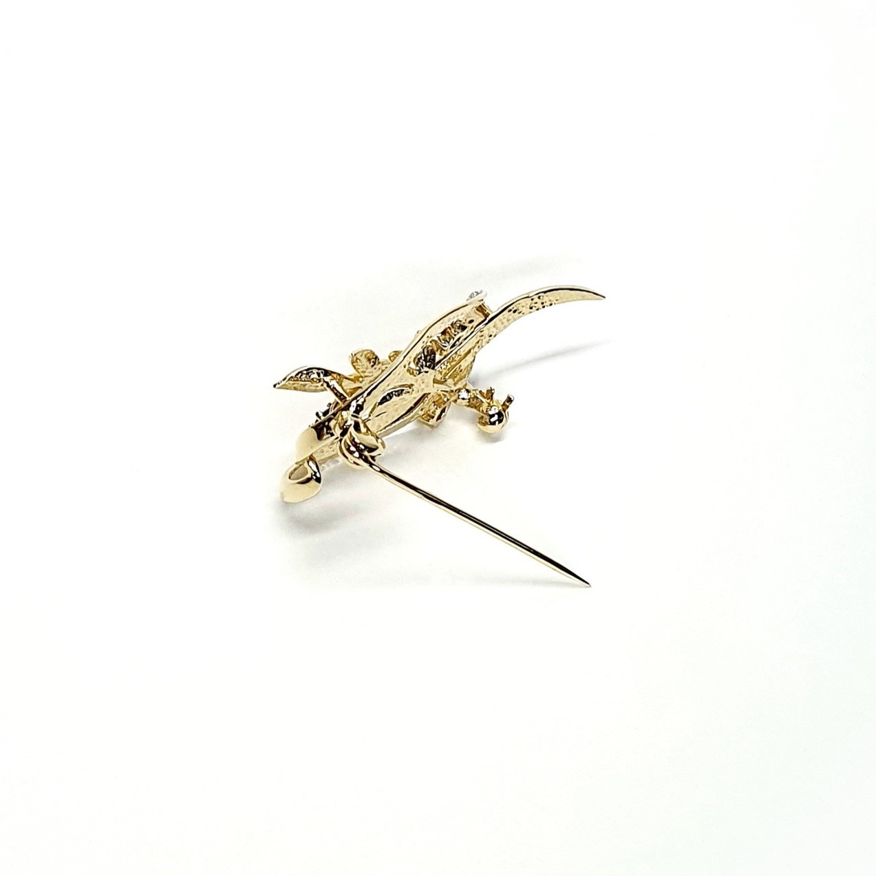 9ct yellow gold brooch with a sprig of seven leaves coming through a floral swirl of polished and barked yellow gold with three diamonds set into a small white rhodium section 