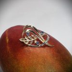 Brooch pictured sitting on a mango.