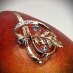 Brooch pictured sitting on a mango.