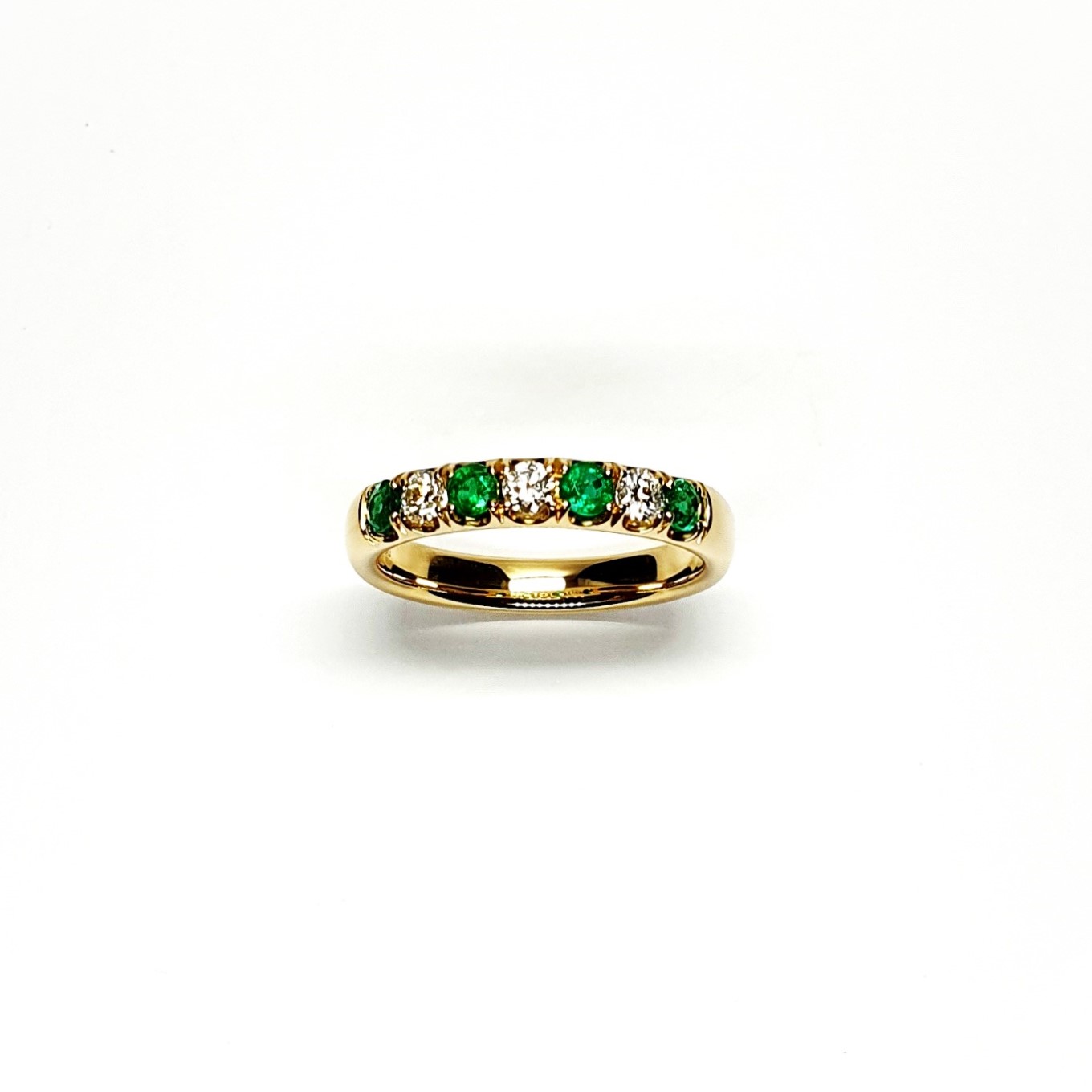 18ct yellow gold seven-stone eternity ring 3.5mm wide set with four 2.8mm round emeralds and three 2.8mm round diamonds in four claw settings
