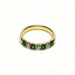 18ct yellow gold seven-stone eternity ring 3.5mm wide set with four 2.8mm round emeralds and three 2.8mm round diamonds in four claw settings