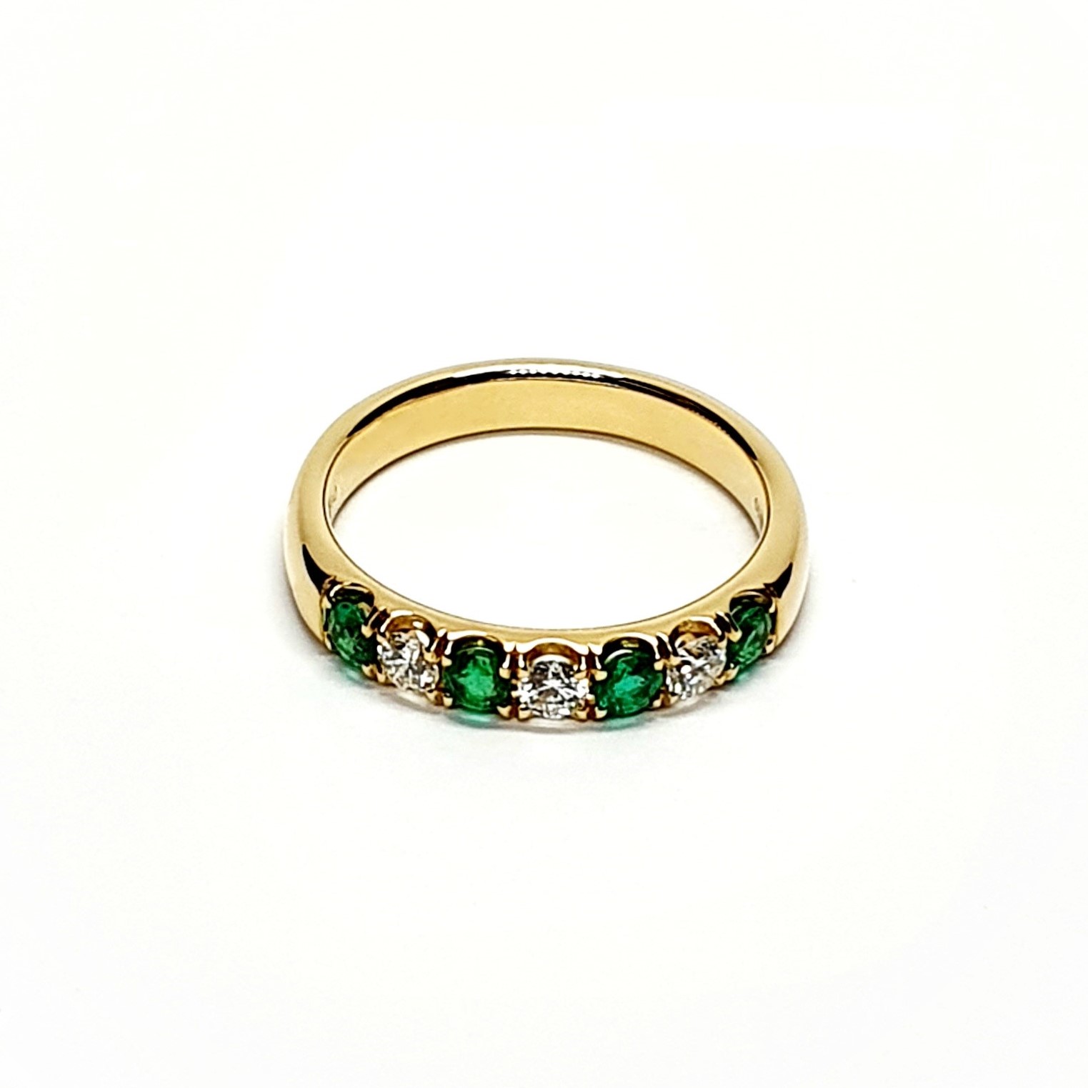 18ct yellow gold seven-stone eternity ring 3.5mm wide set with four 2.8mm round emeralds and three 2.8mm round diamonds in four claw settings