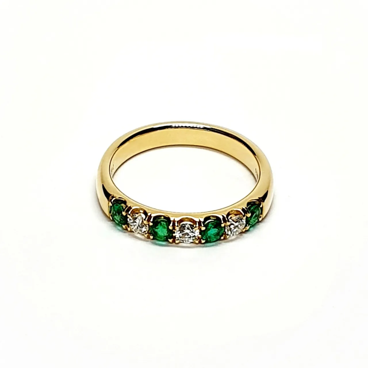 18ct yellow gold seven-stone eternity ring 3.5mm wide set with four 2.8mm round emeralds and three 2.8mm round diamonds in four claw settings