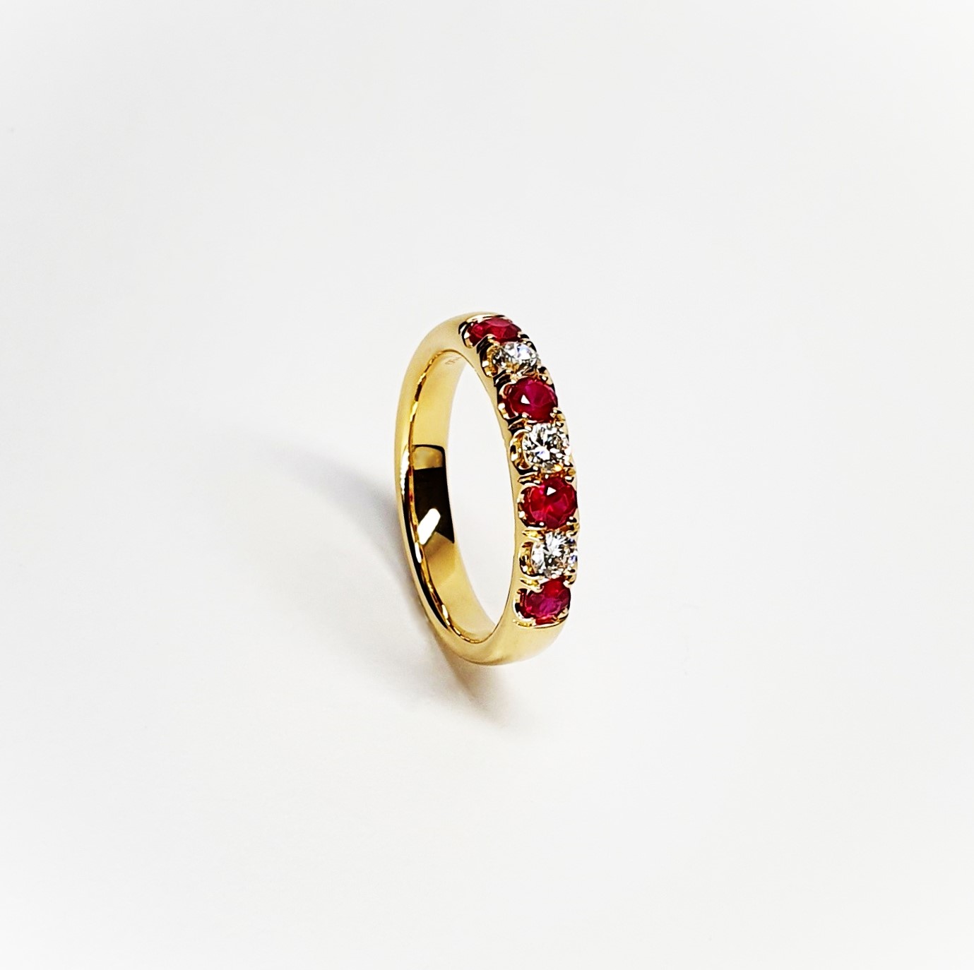 18ct yellow gold ruby and diamond half eternity ring set with three round white diamonds and four round blood red rubies, a solid tactile ring with rounded edges