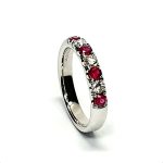 18ct white gold ruby and diamond half eternity ring set with three round white diamonds and four round blood red rubies, a solid tactile ring with rounded edges.